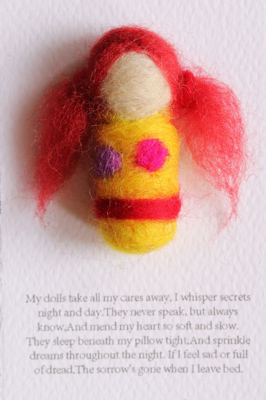 Felted doll with red hair and yellow body on a white background