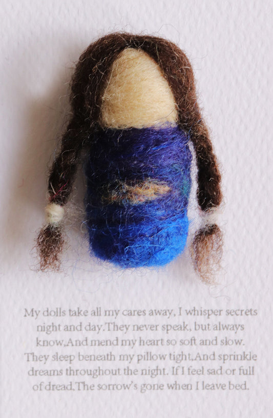 Felted doll with long brown hair and a blue outfit on a white background
